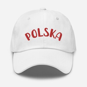 Puede incluir: Gorra de béisbol blanca con el texto "POLSKA" bordado en rojo.