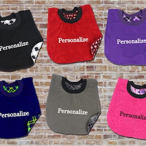 May include: Six pet bibs in various colors: black, red, purple, blue, gray, and pink. Each bib has a contrasting patterned lining and the word "Personalize" in white text.