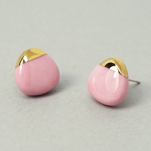 Op de afbeelding: Een paar roze keramische oorbellen met een gouden rand. De oorbellen zijn druppelvormig.