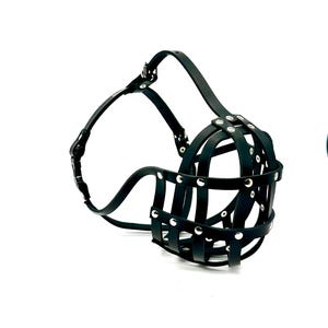 Puede incluir: Boquilla de perro de cuero negro con un diseño similar a una jaula. La boquilla presenta una serie de correas horizontales y verticales aseguradas con remaches plateados. Una correa se extiende sobre la cabeza del perro y alrededor del cuello, sujeta con una hebilla.