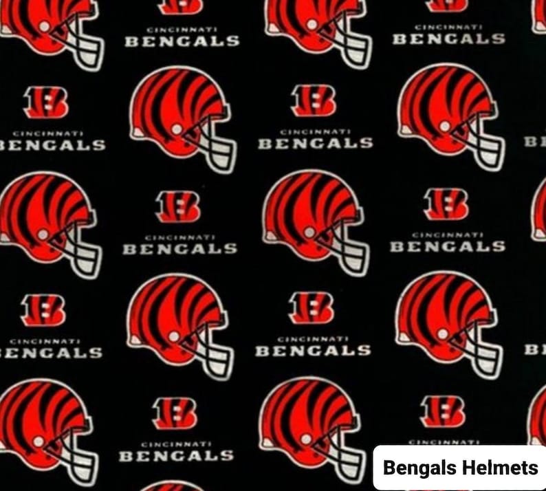 May include: Black fabric with a repeating pattern of red and black Cincinnati Bengals helmets and the words "Cincinnati Bengals".