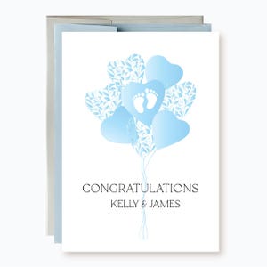 May include: A white card with a blue and white design of balloons with baby footprints. The card says "Congratulations Kelly & James".