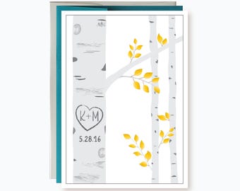 May include: A rectangular greeting card featuring a white background with illustrations of grey birch tree trunks and bright yellow leaves. A heart shape is carved into the main trunk containing the letters K+M and the date 5.28.16 below it.