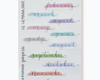 May include: A set of twelve colorful monthly planner stickers with handwritten month names in black ink. The stickers are on a white background. IG: HEMANA.PAPERIE
