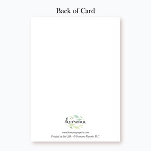 Puede incluir: La parte posterior de una tarjeta blanca con una corona floral verde y el texto "hemana" en letra cursiva negra. Debajo de la corona est&aacute; el texto "www.hemanapaperie.com" y "Impreso en los EE. UU. - &copy; Hemana Paperie, LLC".