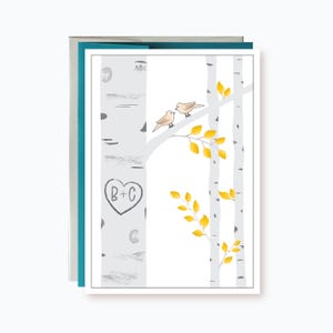 May include: A greeting card featuring a white birch tree illustration with two small tan birds perched on a branch. The tree trunk displays a carved heart shape containing the letters B+C. Bright yellow leaves are scattered on the branches.