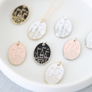 May include: A set of eight oval-shaped pendants featuring a stylized castle design. The pendants are in various colors, including black, white, pink, and silver.
