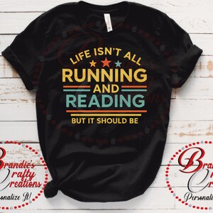 May include: Black t-shirt with the text "LIFE ISN'T ALL RUNNING AND READING BUT IT SHOULD BE" in yellow, orange, and teal. The shirt has a crew neck and short sleeves. The text is centered on the front of the shirt.
