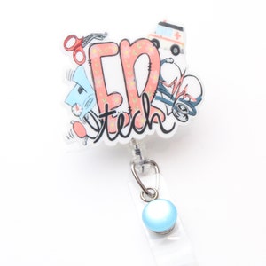 May include: A white and pink retractable badge holder with a blue button. The holder features a cartoon illustration of medical equipment and the text "ER tech".