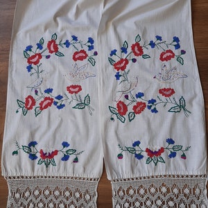 May include: White linen scarf with embroidered floral and bird design. The embroidery features red, blue, and green colors. The bottom edge has a white lace trim.