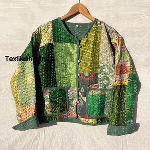 Könnte beinhalten: Eine grüne gesteppte Jacke mit Patchwork-Muster. Die Jacke hat einen Knopfverschluss und zwei Taschen. Der Stoff ist eine Mischung aus verschiedenen Texturen und Mustern.
