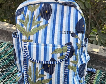 Peut inclure: Sac à dos à rayures bleues et blanches avec un motif floral. Le sac à dos a une poche avant et des poches latérales. Le texte "TEXTILESHUB" est visible sur le devant. Fabriqué en tissu matelassé.