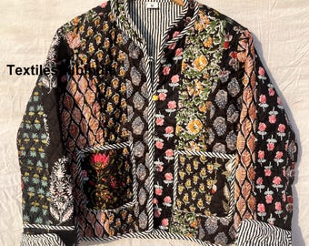 May include: Black quilted jacket with a floral print and a zip closure. The jacket has a mandarin collar and two patch pockets.