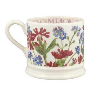 May include: A white ceramic mug featuring a botanical illustration of red campion flowers and small blue forget-me-not blossoms. The interior rim of the mug displays the text RED CAMPION in a purple font, and the mug has a curved handle.