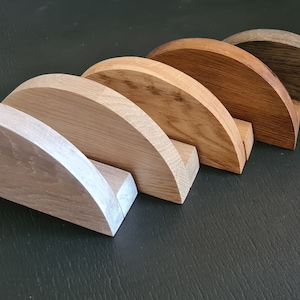 May include: Five wooden half-round pieces in various shades of brown, from light to dark, arranged in a row from left to right.