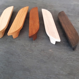 Op de afbeelding: Zes houten ladegrepen in verschillende bruintinten, waaronder naturel hout, lichtbruin, donkerbruin en zwart.