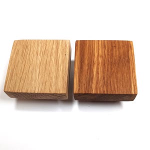 May include: Two square wooden knobs, one is a natural wood colour and the other is stained a darker brown.
