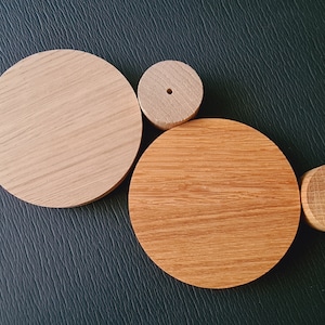 Peut inclure: Quatre cercles en bois de différentes tailles, avec une finition en bois naturel. Le plus grand cercle est brun clair, le deuxième plus grand est brun foncé et les deux plus petits cercles sont brun clair.