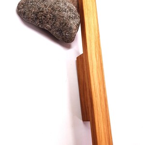 May include: A wooden cabinet door handle with a rectangular shape and a natural wood finish.