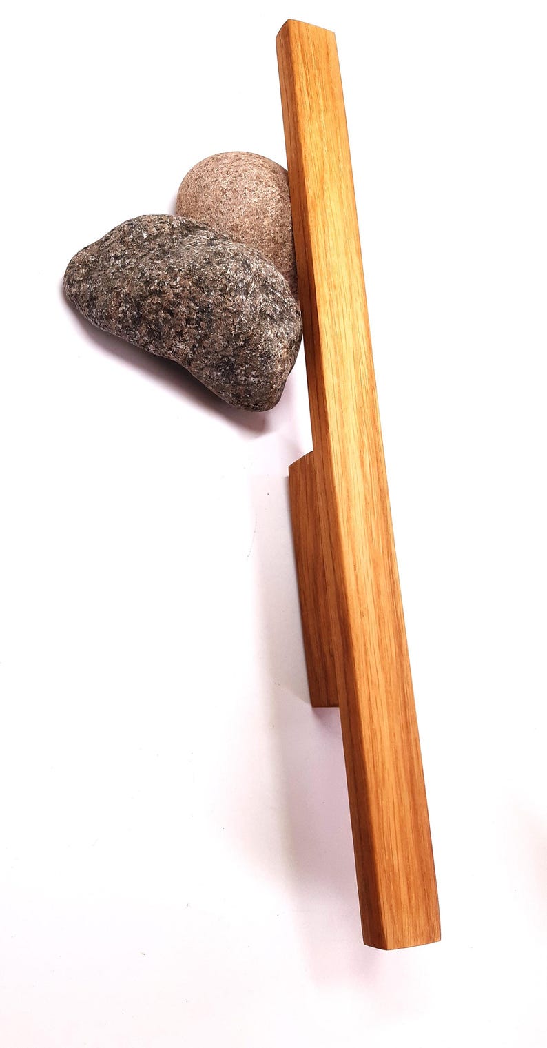 May include: A wooden cabinet door handle with a rectangular shape and a natural wood finish.