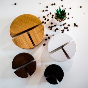 May include: Four round dividers made of wood and marble, each with three sections. The dividers are in different colours: brown, black, white, and natural wood. The dividers are arranged in a circle on a white surface.