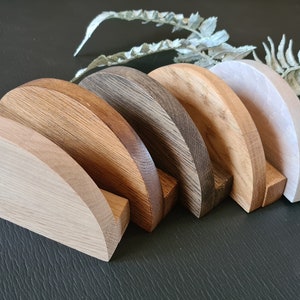 May include: Five wooden half-circle shelves in various shades of brown, arranged in a row from lightest to darkest.