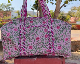 May include: A pink and green floral print cotton tote bag with pink and white striped handles. The bag has a zipper closure and is perfect for carrying everyday essentials.