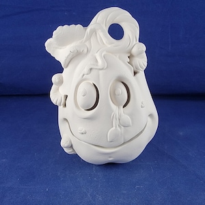 May include: A white ceramic pumpkin-shaped decoration with a smiling face, large eye cutouts, and a curly stem. The pumpkin has a textured surface and small details, perfect for Halloween or fall decor.