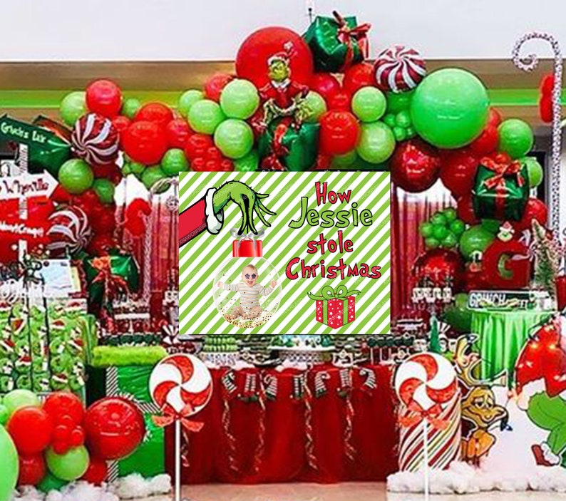 May include: A festive Christmas party scene with red, green, and white decorations. The centerpiece features a sign that reads "How Jessie stole Christmas" with a baby in a Christmas ornament. Balloons, gifts, and candy canes complete the holiday theme.
