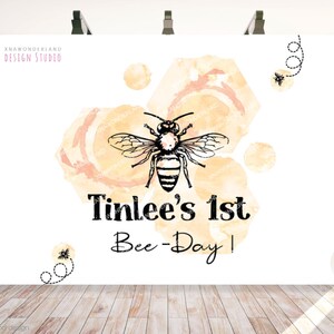 K&ouml;nnte beinhalten: Ein wei&szlig;er Hintergrund mit einem Aquarelldesign aus gelben und orangen Kreisen und einer Biene. Der Text "Tinlee's 1st Bee-Day!" ist in Schwarz geschrieben.
