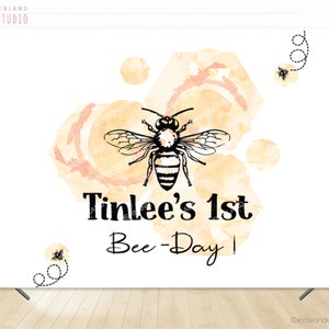 K&ouml;nnte beinhalten: Ein wei&szlig;er Hintergrund mit einem Aquarelldesign aus gelben und orangen Kreisen und einer Biene. Der Text "Tinlee's 1st Bee-Day!" ist in Schwarz unter der Biene geschrieben.