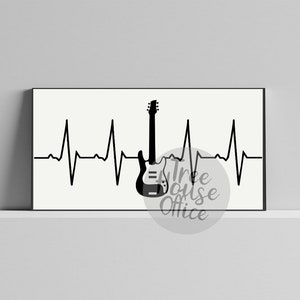 Puede incluir: Impresi&oacute;n en blanco y negro de una guitarra con una l&iacute;nea de latido del coraz&oacute;n. La impresi&oacute;n est&aacute; enmarcada en un marco negro y est&aacute; en una pared blanca.