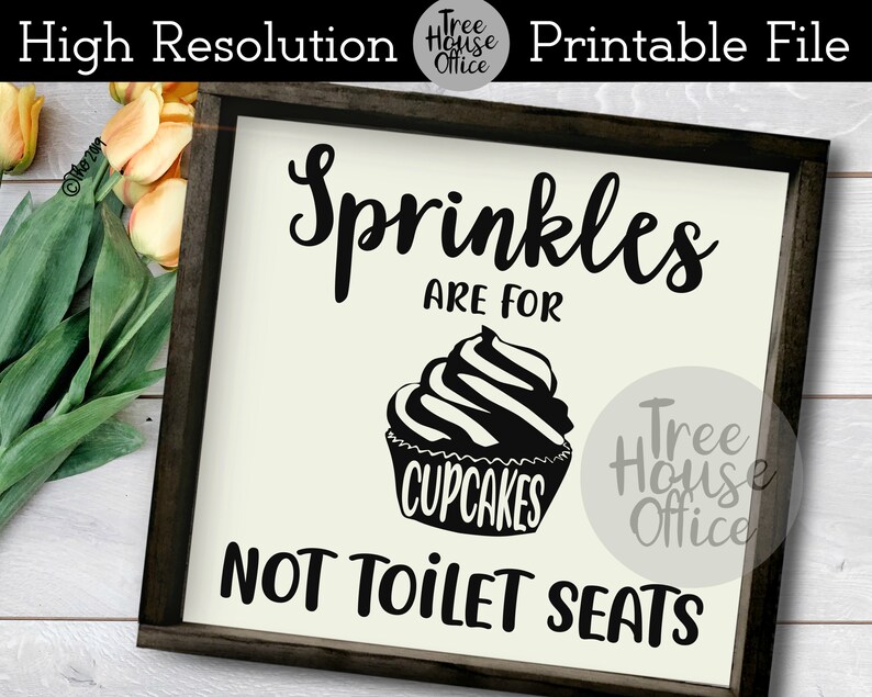 May include: A white sign with black text and a black cupcake graphic. The sign reads "Sprinkles are for cupcakes, not toilet seats".