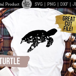 Turtle silhouette with wildflowers inside SVG design shown applied to a white shirt with plaid overshirt
