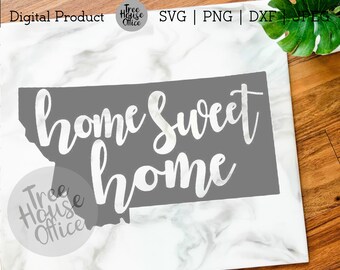 May include: A gray silhouette of the state of Montana with the text "home sweet home" in white cursive lettering.