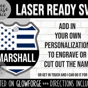 Pu&ograve; includere: Un design di bandiera americana blu e bianca su una forma a scudo con il nome "MARSHALL" stampato sotto. Il testo "LASER READY SVG" &egrave; nella parte superiore dell'immagine. Il testo "ADD IN YOUR OWN PERSONALIZATION TO ENGRAVE OR CUT OUT THE NAME" &egrave; sul lato destro dell'immagine. Il testo "TESTED ON GLOWFORGE *** DIRECTIONS INCLUDED!" &egrave; nella parte inferiore dell'immagine.
