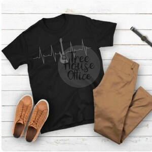 Puede incluir: Camiseta negra con un gr&aacute;fico de una guitarra y una l&iacute;nea de latido del coraz&oacute;n. El texto "Tree House Office" est&aacute; impreso en la camiseta.
