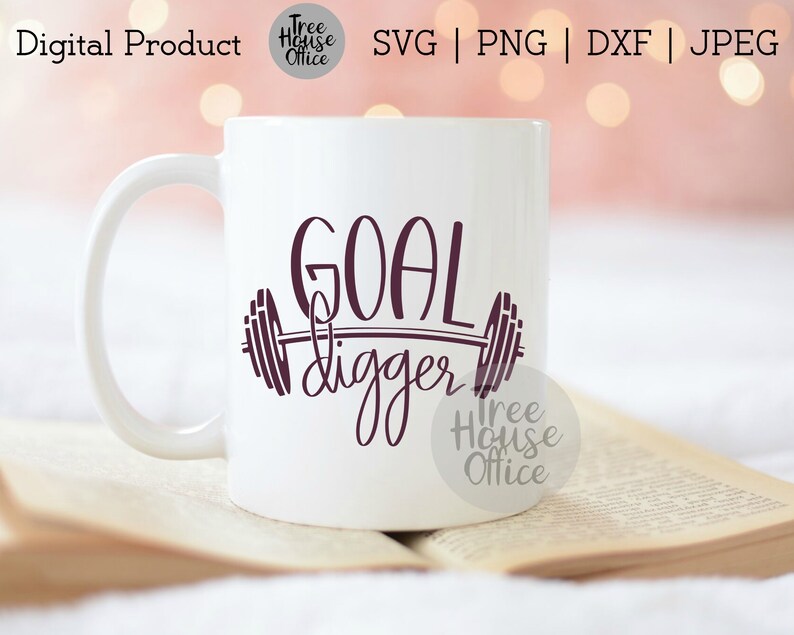 K&ouml;nnte beinhalten: Eine wei&szlig;e Keramiktasse mit einem violetten Design, auf dem "GOAL digger" steht, mit einer Langhantel und Gewichten auf beiden Seiten des Wortes "digger".
