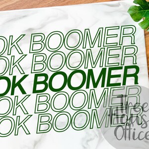 May include: White background with the phrase "OK Boomer" repeated five times in green and black text. The text is outlined in black and the words "OK" are in green.