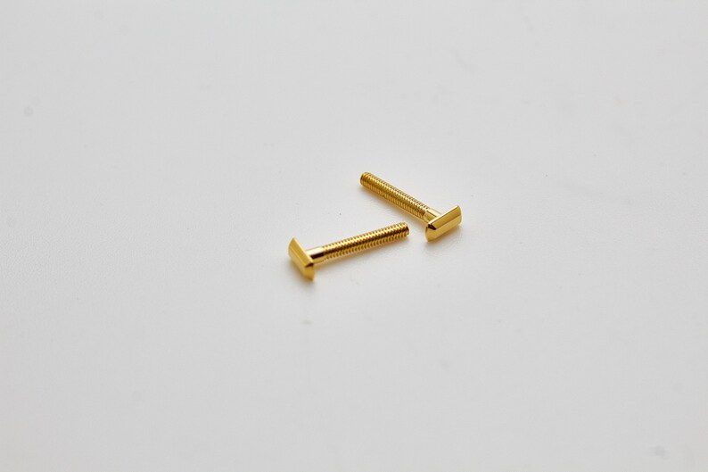 May include: Two gold colored t-slot bolts with a square head