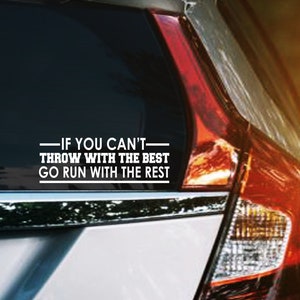 May include: A car window decal with the text "IF YOU CAN'T THROW WITH THE BEST GO RUN WITH THE REST" in white. The decal is on the rear window of a silver car, with a red taillight visible.