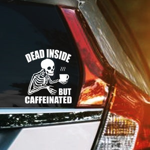 May include: A white vinyl sticker with a skeleton holding a cup of coffee and the text "Dead inside but caffeinated".