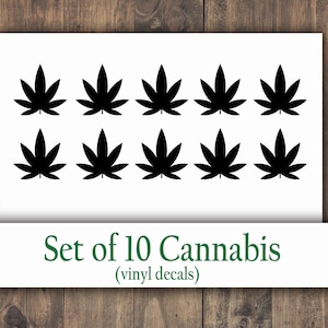 May include: A set of ten black cannabis leaf vinyl decals. The leaves are evenly spaced on a white background. The text "Set of 10 Cannabis (vinyl decals)" is printed in green below the leaves.