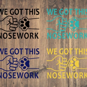 May include: Four variations of a graphic design with the text "WE GOT THIS NOSEWORK" in black, teal, navy blue, and yellow. The graphic features two fists bumping with a paw print in between.