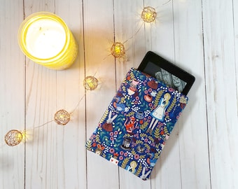 May include: A blue and white e-reader cover with a whimsical Alice in Wonderland design. The cover features a variety of characters and objects from the story, including Alice, the Mad Hatter, the Cheshire Cat, and teacups. The cover is made of a soft, durable fabric and is perfect for protecting your e-reader.