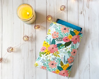May include: A floral book sleeve with a blue book inside. The sleeve has a light blue background with pink, yellow, and green flowers.