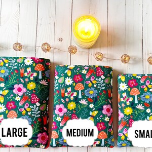 May include: Three green fabric zippered pouches with a floral and mushroom print. The pouches are labeled "LARGE", "MEDIUM", and "SMALL".