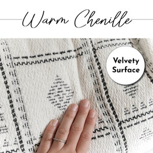 Puede incluir: Primer plano de una tela de chenilla blanca y negra con un patr&oacute;n de rombos. Una mano est&aacute; tocando la tela, destacando su textura aterciopelada. El texto "Velvety Surface" est&aacute; escrito en un c&iacute;rculo.