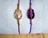 Bracelet protection avec un scarabée en cristal de Swarovski beige ou violet et perles en plaqué or