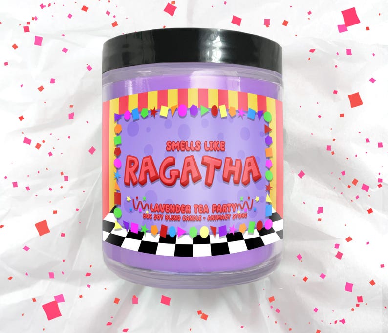 Puede incluir: Una vela de color lavanda en un tarro transparente con tapa negra. La etiqueta dice "Smells Like Ragatha Lavender Tea Party". La etiqueta tiene un fondo morado con formas coloridas y un patr&oacute;n de cuadros blanco y negro en la parte inferior.